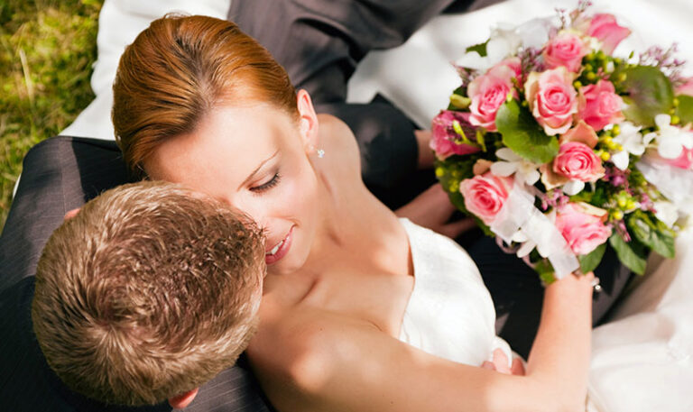 Brautpaar mit Rosenbukett von oben fotografiert