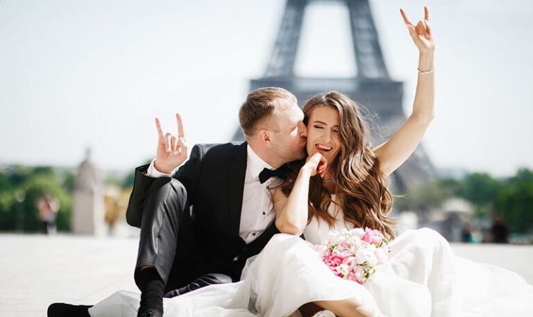 After-Wedding-Shooting: Paar aus Mannheim sitzt auf dem Boden des Trocaderos in Paris mit unscharfen Eiffelturm im Hintergrund