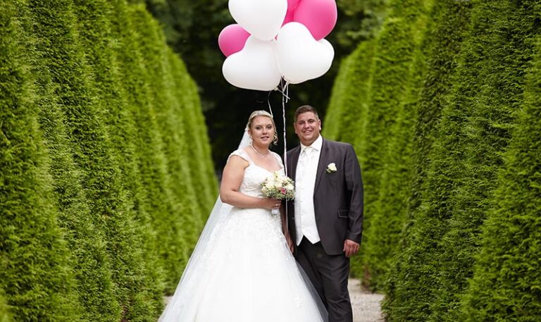 Brautpaarsteht mitten in der Thuyen-Allee im Park des Schwetzinger Barock-Schlosses