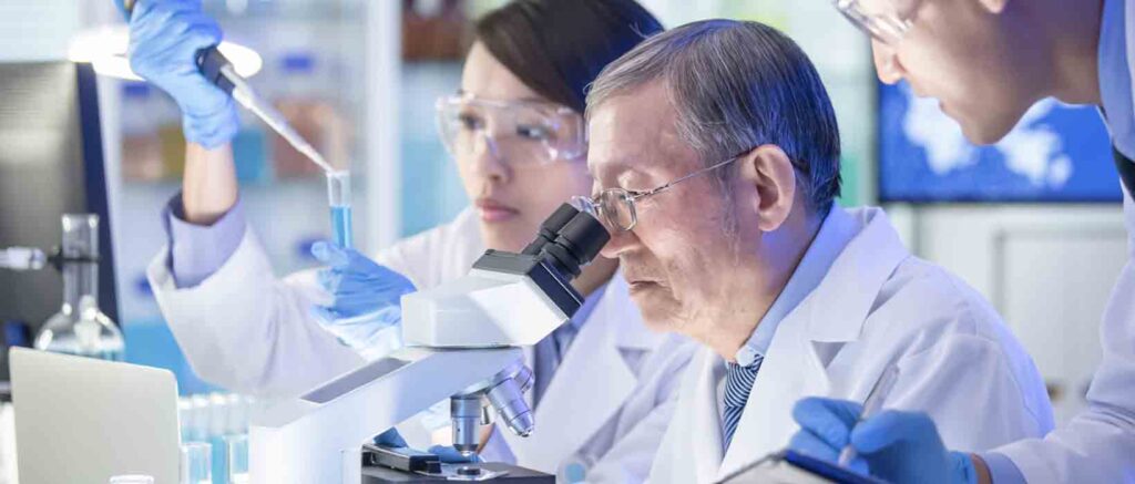 Forschungsabteilung eines Pharmaherstellers 3 Chemiker am Mikroskop