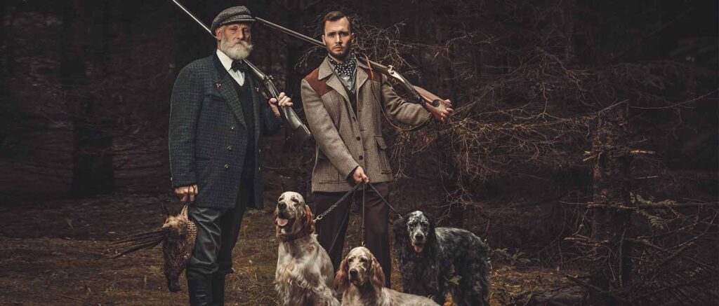 inszenierte Luxus-Fotografie: 2 Jäger im Olfstyle mit 3 Jagdhunden und Fasan